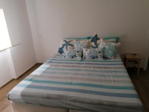 a bed with blue and white sheets and pillows at La conchiglia in Rapallo