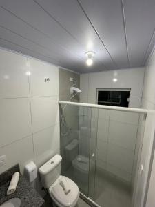 uma casa de banho com um WC e uma cabina de duche em vidro. em Do Parque Pousada Comfort em Penha