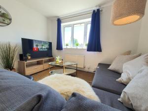 a living room with a couch and a tv at Thesiger Court Apartments - Free Private Parking - by Property Promise in Cardiff