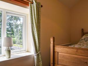 a bedroom with a bed and a window at Hengegin - Uk39874 in Llandybie
