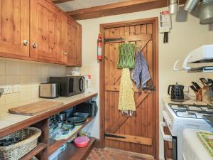 a kitchen with a wooden door and a stove at The Cowshed in Penrith