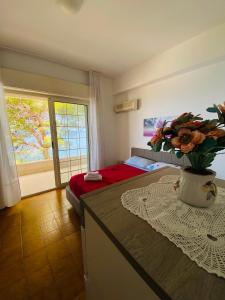 um quarto com uma cama e um vaso de flores sobre uma mesa em Palermo relax family house em Altavilla Milicia