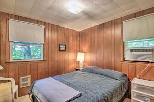 Schlafzimmer mit Holzwänden, einem Bett und einem Fenster in der Unterkunft Raymond Retreat with 200 Feet of Private Beach! in Raymond