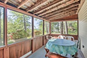 a screened in porch with a table and chairs at Raymond Retreat with 200 Feet of Private Beach! in Raymond