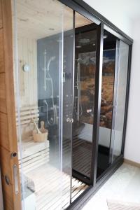 Habitación con baño acristalado con ducha. en Les Chalets du Bois Blanc, 