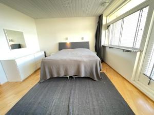 ein Schlafzimmer mit einem Bett und einem großen Fenster in der Unterkunft Cosy and spacious apartment in Reykjavik in Reykjavík