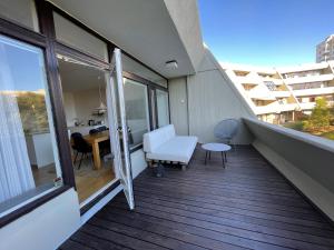 a balcony with a white couch and a table at Cosy and spacious apartment in Reykjavik in Reykjavík