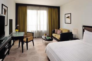 a hotel room with a bed and a living room at Avani Deira Dubai Hotel in Dubai