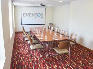 une salle de conférence avec une grande table et des chaises dans l'établissement Hotel Estelar San Isidro, à Lima