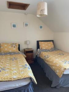 a bedroom with two beds and a table with a lamp at Albion Cottages in Bridlington