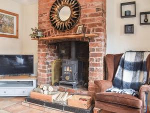 a living room with a brick fireplace with a mirror at Star Yard in Tenbury