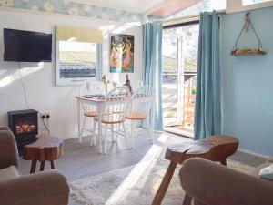 een woonkamer met een tafel en stoelen en een open haard bij Twit Too Woo - Uk6760 in Cenarth