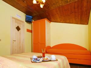 Un dormitorio con una cama y una mesa con comida. en La Pinetina, en San Massimo