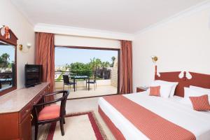 ein Hotelzimmer mit einem Bett und einem Balkon in der Unterkunft Aladdin Beach Resort - Families and Couples Only in Hurghada