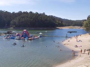 una playa con un montón de gente en el agua en Casa campo ermal en Braga