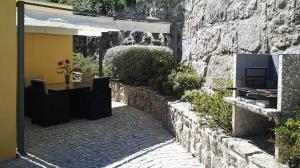 eine Steinmauer mit einem Tisch und einem Gebäude in der Unterkunft Casa campo ermal in Braga
