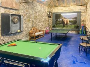 una sala de billar con mesa de billar y una foto de una vaca en Fochy Cottage en Milnathort