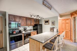 a kitchen with wooden cabinets and a counter top at Trails End Mountain Breeze Condo - Ski In - Out - Stroll To Main Street in Breckenridge