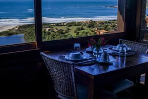 a dining table with a view of the ocean at Solar Mirador Exclusive Resort e SPA in Praia do Rosa