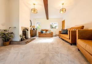 uma sala de estar com sofás e uma lareira em No1 Little Barrow Barns - Sleeps 10 em Chester