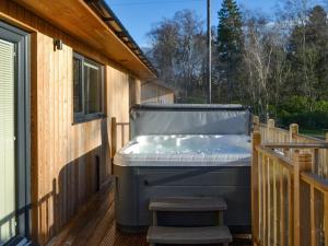 a hot tub sitting on the deck of a house at Juniper Lodge - UKC3931 in Otterburn