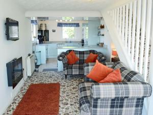 uma sala de estar com dois sofás e uma cozinha em Seascape em Balintore
