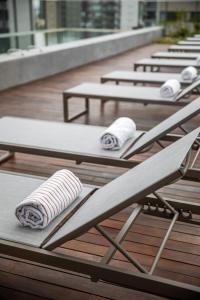a row of chaise lounges on a deck at Noon Vila Madalena in Sao Paulo