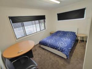 1 dormitorio con cama, escritorio y mesa en 321 Milton, en Brisbane