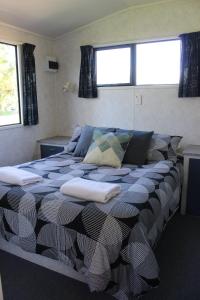 ein Schlafzimmer mit einem großen Bett mit Kissen darauf in der Unterkunft Russell-Orongo Bay Holiday Park in Russell