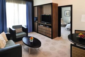 a living room filled with furniture and a tv at Avani Deira Dubai Hotel in Dubai