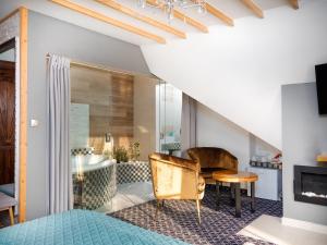 ECO Villa Grand Karpatia Ski&Spa في مورزاسيخله: غرفة نوم بسرير وحمام مع حوض استحمام