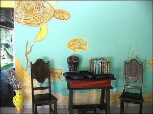 a room with a table and two chairs and a blue wall at Pousada Laguna Mar in Marechal Deodoro