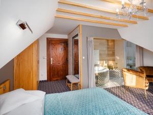 a bedroom with a bed and a bathroom at ECO Villa Grand Karpatia Ski&Spa in Murzasichle
