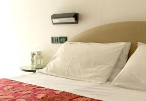 un letto con lenzuola bianche e cuscini sopra di Hotel Stockholm a Rimini