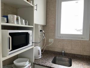 cocina con microondas y fregadero en Estudio en Belén de Escobar