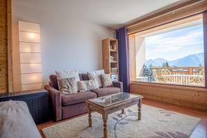 a living room with a couch and a table and a window at Appartement du Poutat - Welkeys in LʼHuez