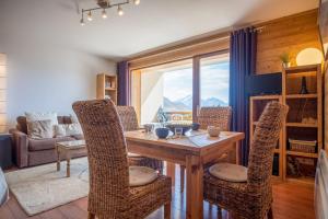 een eetkamer met een houten tafel en stoelen bij Superb apartment with balcony in the heart of Huez - Welkeys in Huez