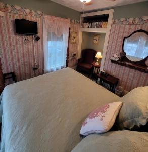 ein Schlafzimmer mit einem großen Bett und einem Spiegel in der Unterkunft Prairie House Manor Bed and Breakfast in De Smet