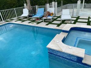 a woman sitting in a chair next to a swimming pool at Luxury 2 Bedroom Rooftop pool View unit #3 in Falmouth