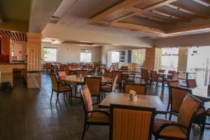 Hotel La Mina Parral في هيدالجو ديل بارال: غرفة طعام مليئة بالطاولات والكراسي