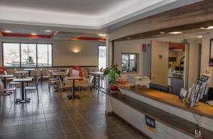un restaurant avec des tables, des chaises et un comptoir dans l'établissement Ace Hotel Annecy, à Annecy