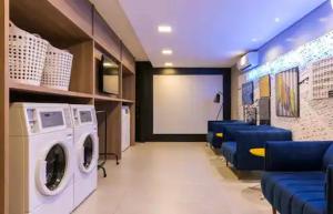 a laundry room with a dryer and blue chairs at 1164 Helbor Stay Batel, Conforto e Estilo no Coração de Curitiba in Curitiba +4 photos