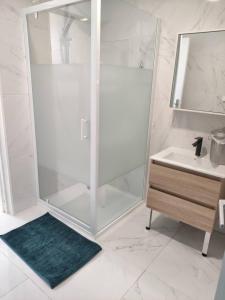 Un baño blanco con ducha y lavabo. en L'annexe de l'usine Logement Moderne de campagne, en Saint-Quentin-Lamotte-Croix-au-Bailly