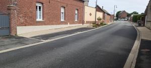 una calle vacía frente a un edificio de ladrillo en L'annexe de l'usine Logement Moderne de campagne, en Saint-Quentin-Lamotte-Croix-au-Bailly