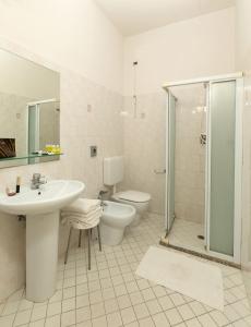un bagno con lavandino, WC e doccia di Hotel Stockholm a Rimini