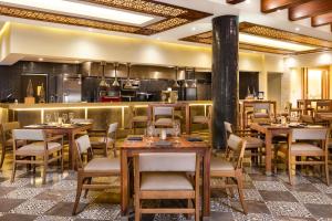 a restaurant with tables and chairs and a kitchen at Villa La Valencia Beach Resort & Spa Los Cabos in San José del Cabo