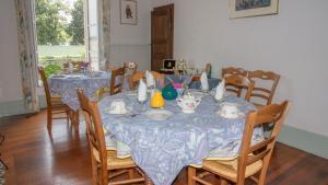 a dining room with a table and chairs with plates and cups at CHEZ PIERRE in Remoncourt