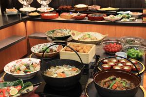 um buffet cheio de muitos tipos diferentes de alimentos em Hotel Hokke Club Kagoshima em Kagoshima