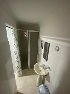 y baño pequeño con lavabo y ducha. en Hostal Casa W en Cartagena de Indias