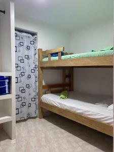 カルタヘナ・デ・インディアスにあるHostal Casa Wの二段ベッド2台、シャワーカーテンが備わる客室です。